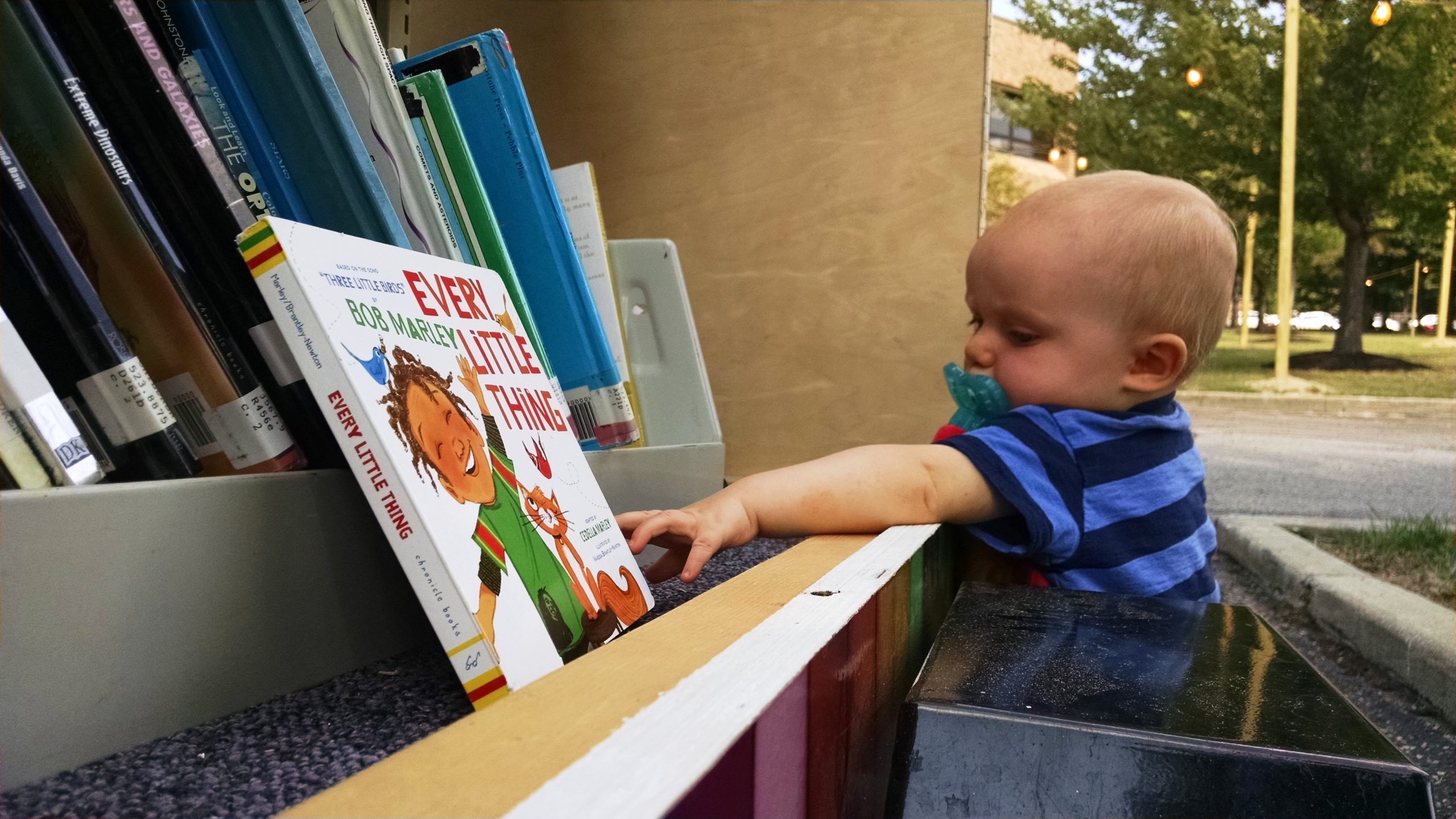 A toddler reaches for a book on the Pop-Up Library during the CityFest celebration in Mentor.